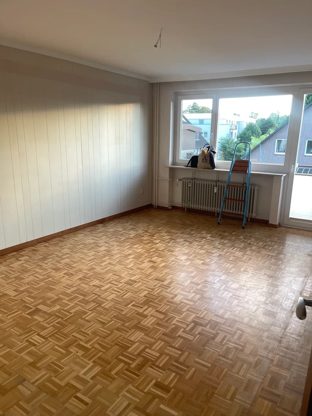 Leeres Wohnzimmer mit freigelegtem Parkett nach der Wohnungsauflösung in Hamburg-Berne