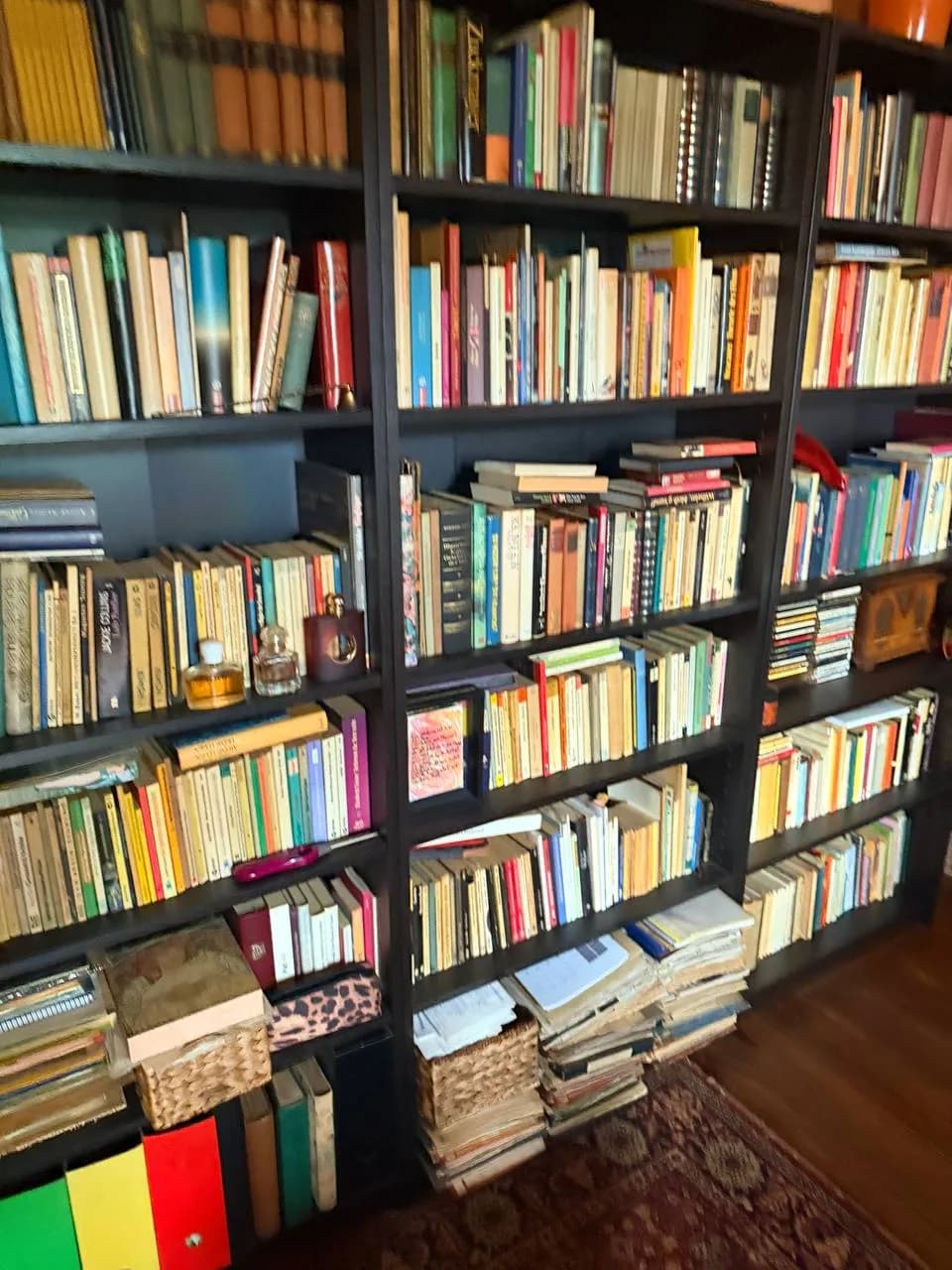Regalwand voller Bücher mit Ordnern und Körben in einer Wohnung am Eppendorfer Weg vor der Wohnungsauflösung