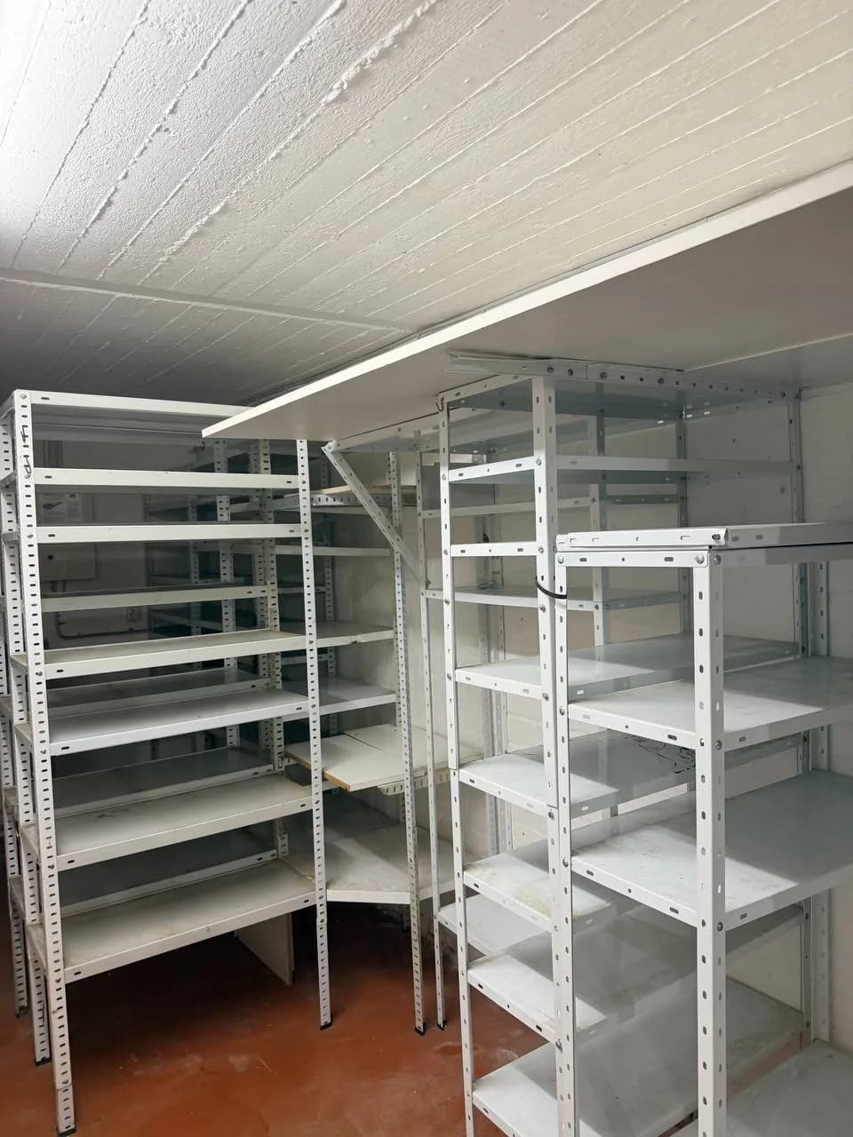 Leere weiße Metallregale im Keller in Fuhlsbüttel nach der Räumung