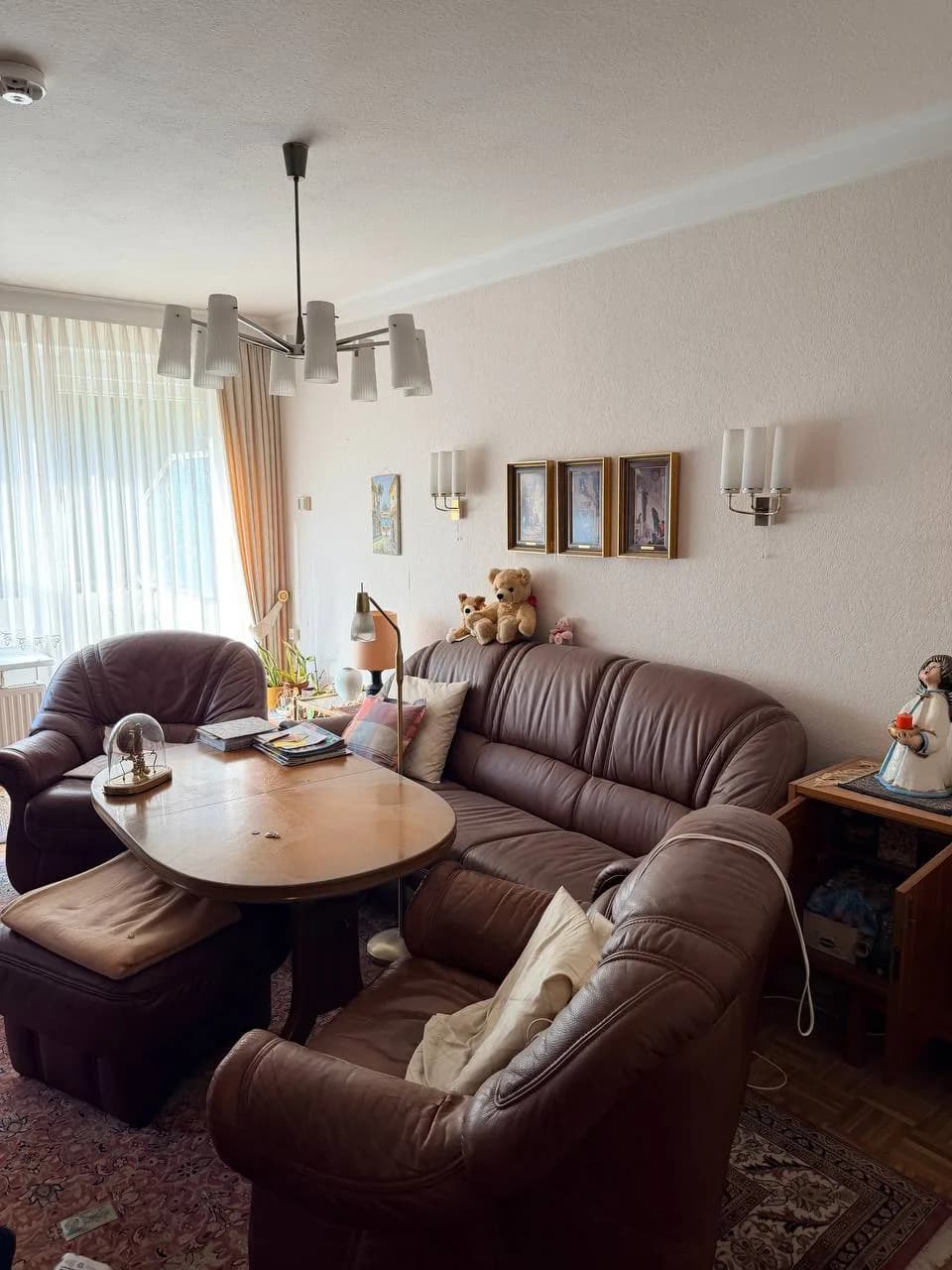 Wohnzimmer in Hamburg-Wandsbek vor der Räumung mit brauner Ledergarnitur, Couchtisch und Kronleuchter