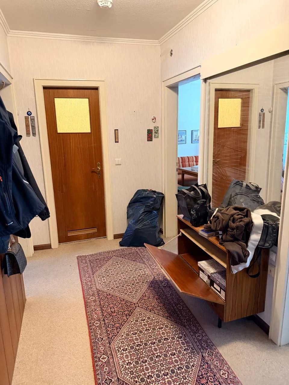 Diele einer Wohnung in Hamburg-Wandsbek vor der Räumung mit Schuhschrank, Läufer und Garderobe