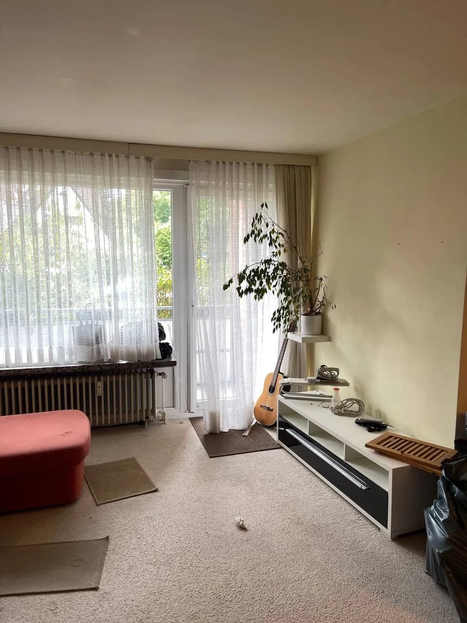 Wohnzimmer in Wedel mit Teppichboden, Sitzhocker, Gitarre und Pflanze vor der Auflösung