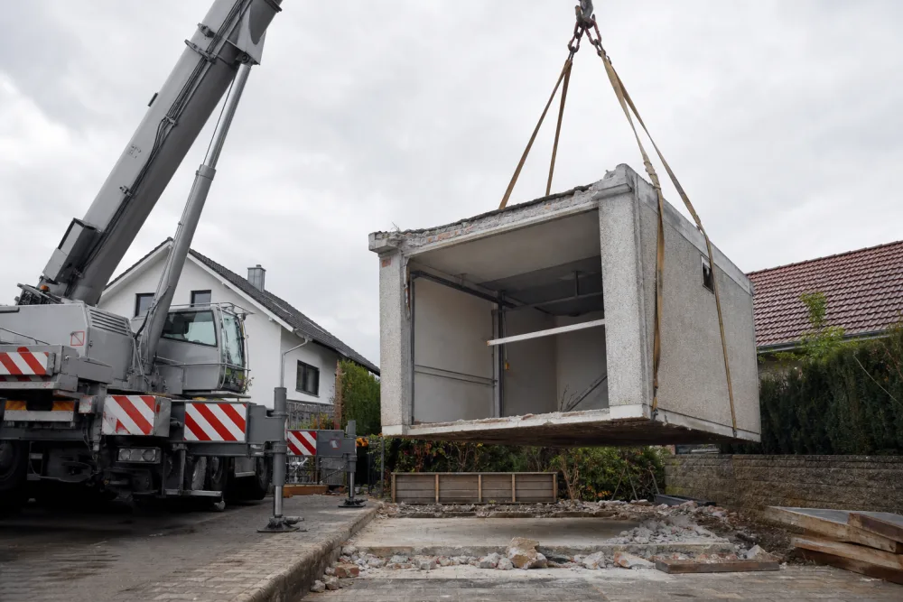 Betonfertiggarage wird mit einem Kran für den Abtransport angehoben