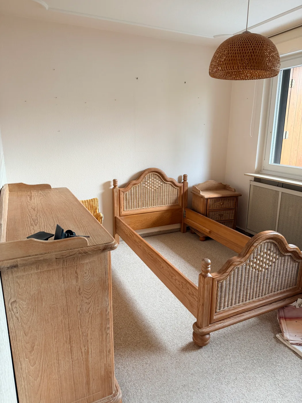 Schlafzimmer mit Eichenbett und Rattaneinsätzen vor der Wohnungsauflösung in Hamburg-Berne