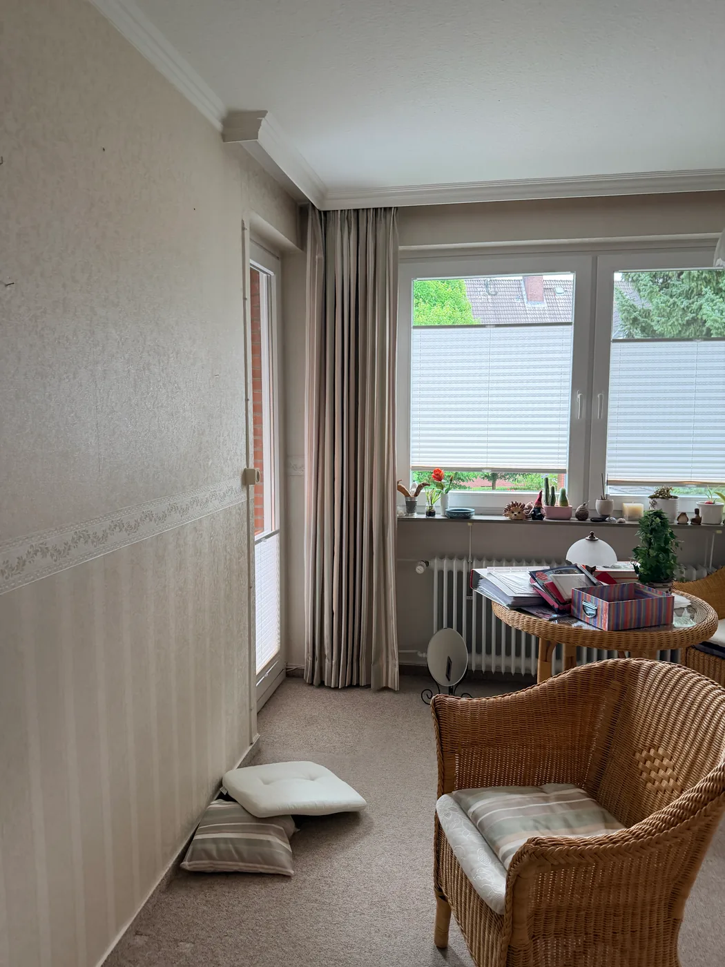 Zimmer mit hellem Teppichboden, Plisseerollos und Korbsessel in Hamburg-Berne vor dem Ausbau