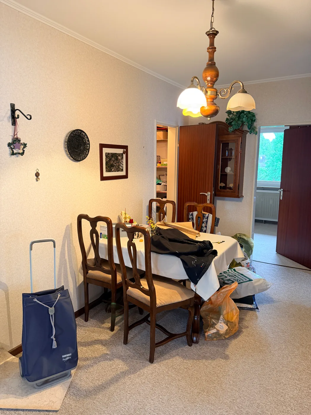 Esszimmer mit Tisch, Stühlen und Vitrine in einer Wohnung in Hamburg-Berne vor der Auflösung