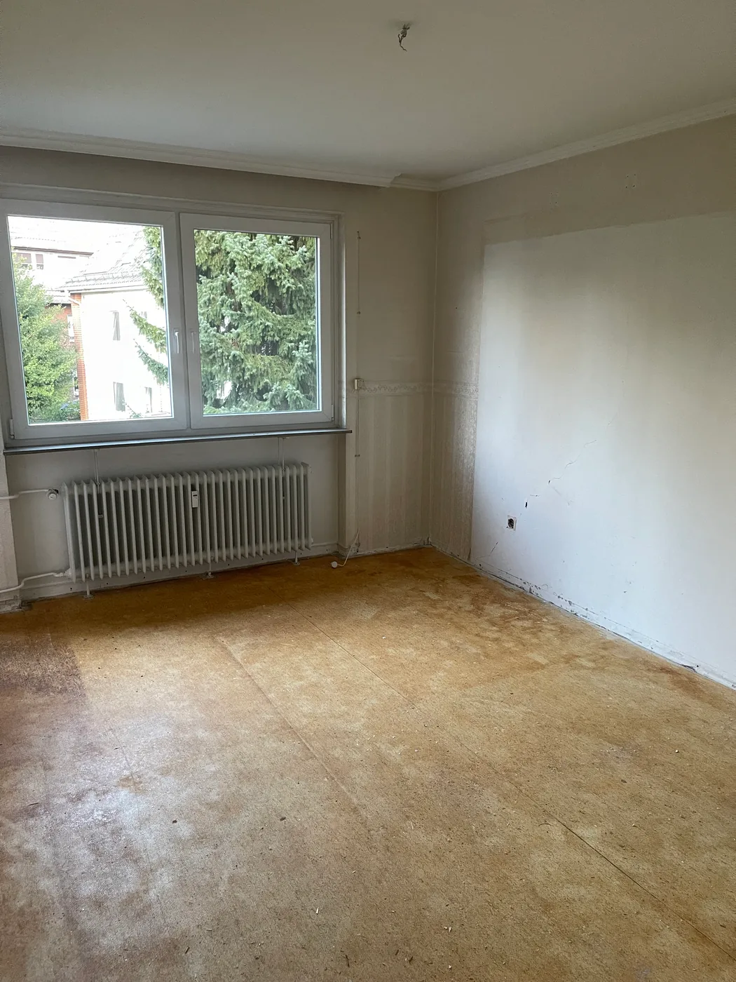 Zimmer in Hamburg-Berne nach dem Entfernen des Teppichbodens, nackter Unterboden mit Kleberresten