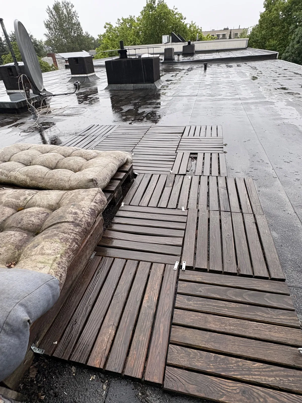 Verwitterte Holzfliesen auf einer Dachterrasse in Hamburg vor dem Rückbau