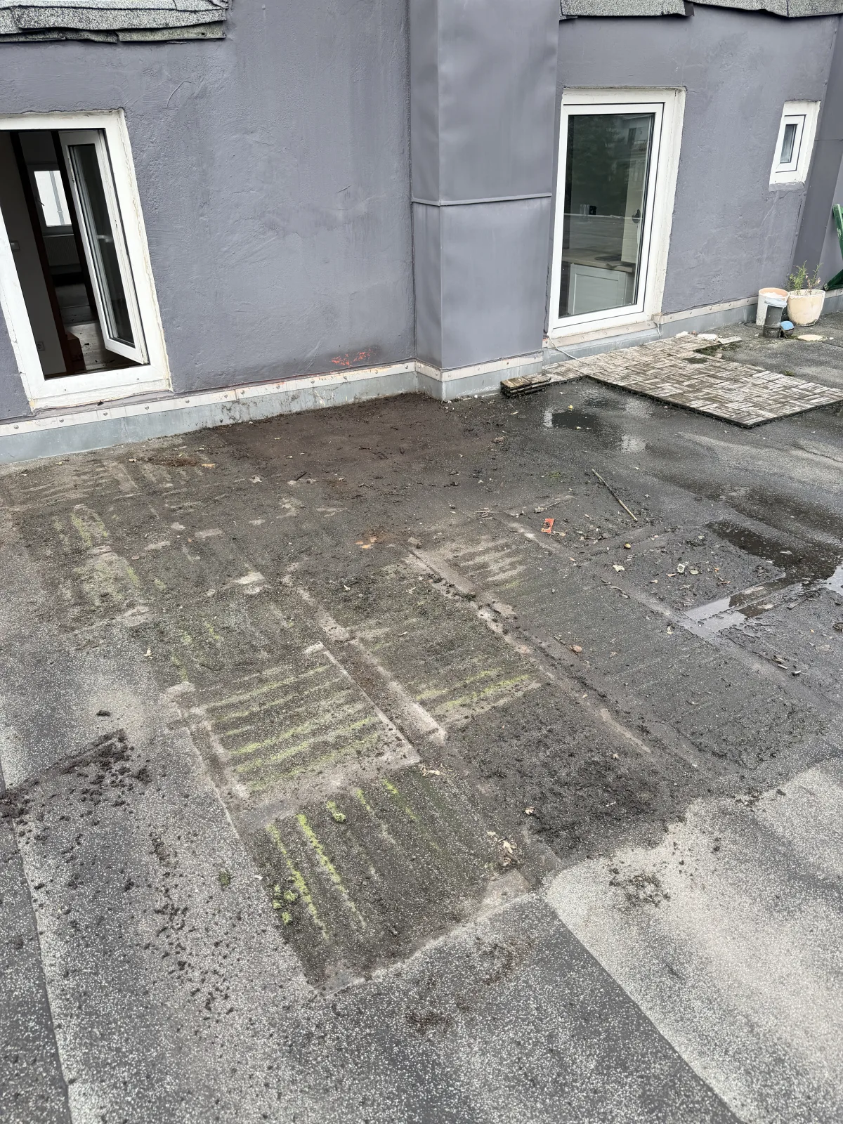 Freigelegte Dachbahn mit Moosabdruck der entfernten Holzfliesen auf einer Dachterrasse in Hamburg