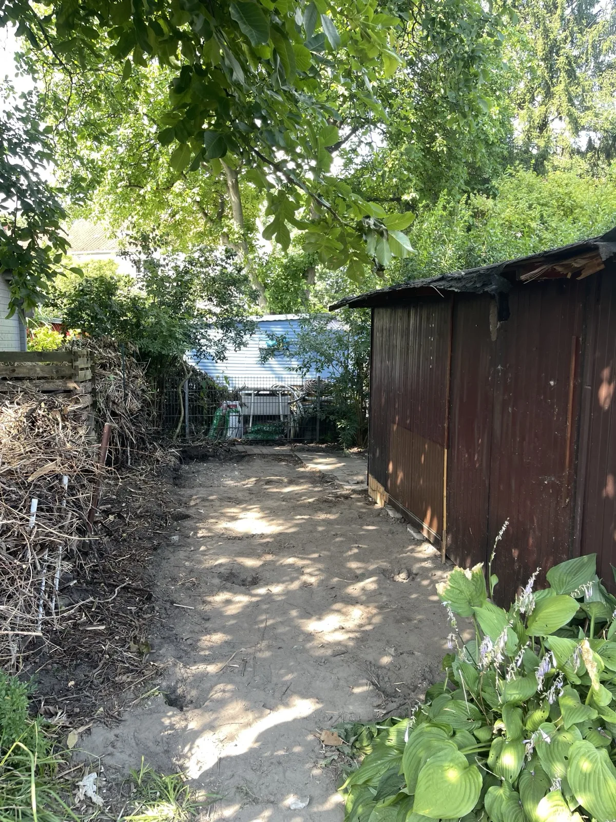 Freigelegter Erdstreifen nach dem Abriss eines Gartenlauben-Anbaus in Hamburg