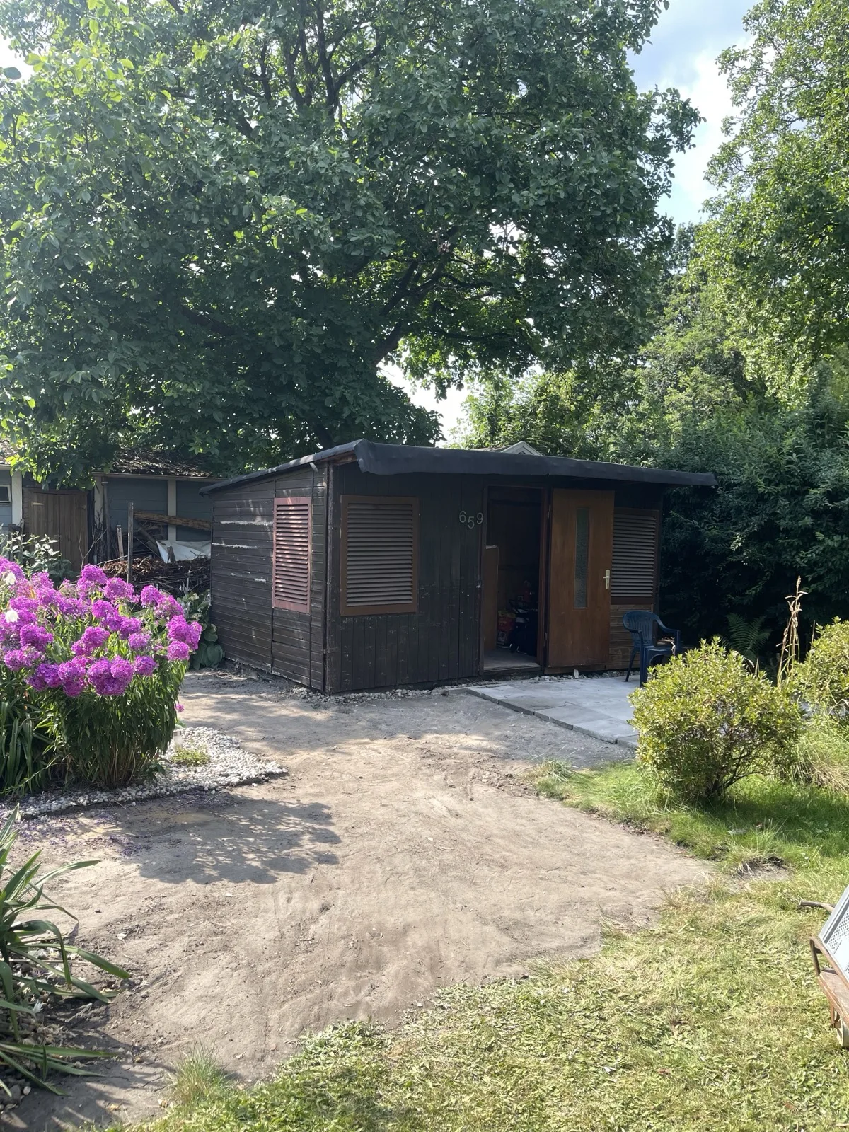 Gartenlaube in Hamburg nach dem Rückbau, alte Gehwegplatten zum Abtransport gestapelt