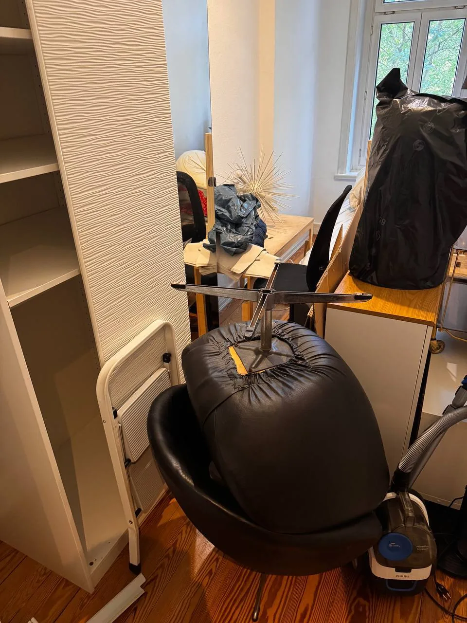 Möbel, Kartons und ein zerlegter Bürostuhl in einem Altbau-Zimmer in Hamburg-Harvestehude vor der Entrümpelung