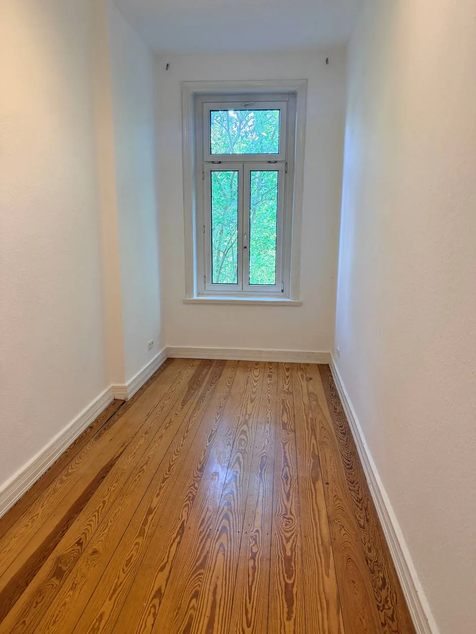 Leeres Altbau-Zimmer an der Isestraße in Hamburg nach Räumung und Renovierung, mit abgeschliffenen Kiefer-Dielen