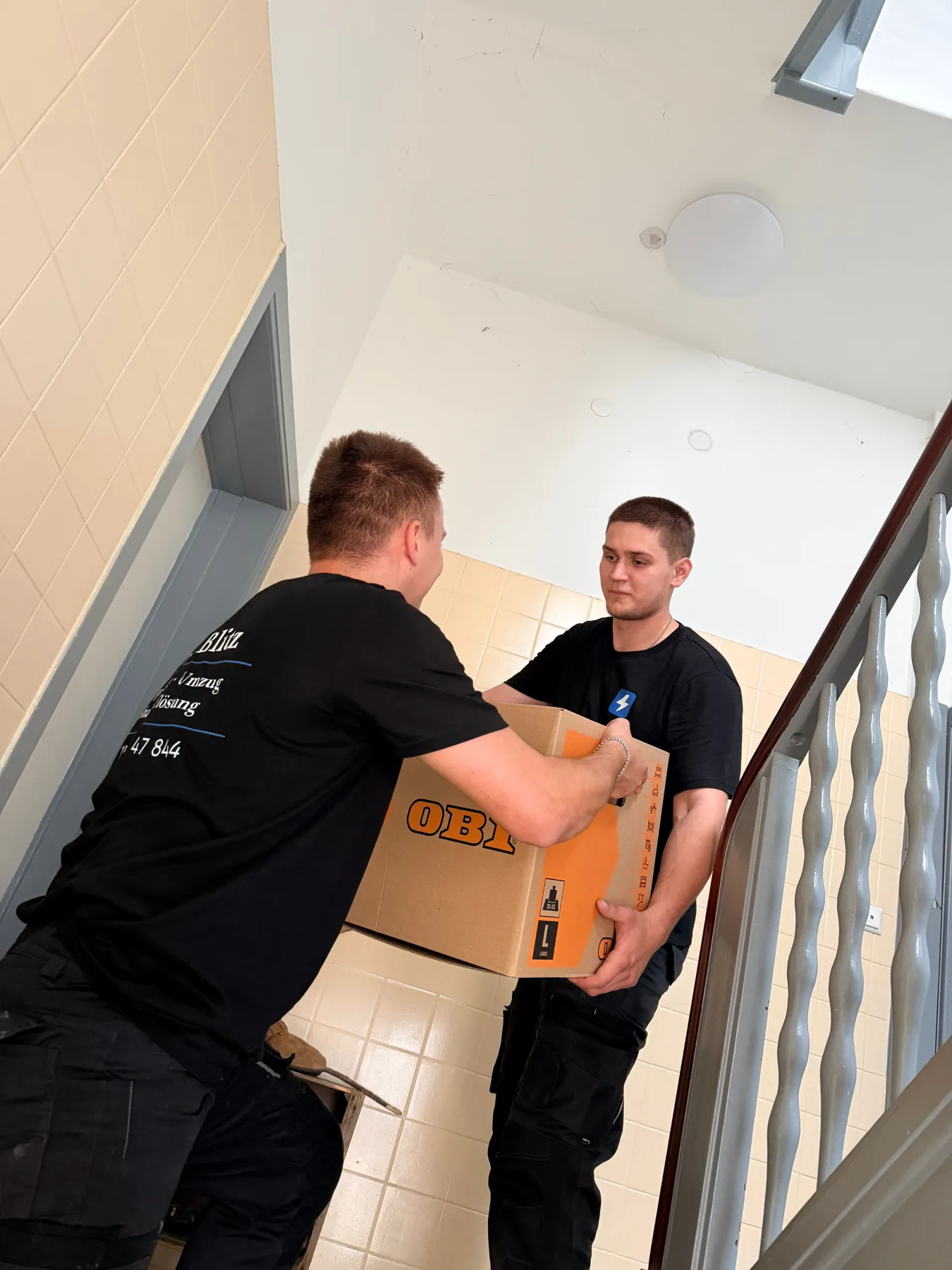 Blitz-Team trägt Kisten im Treppenhaus - Entrümpelung Hamburg