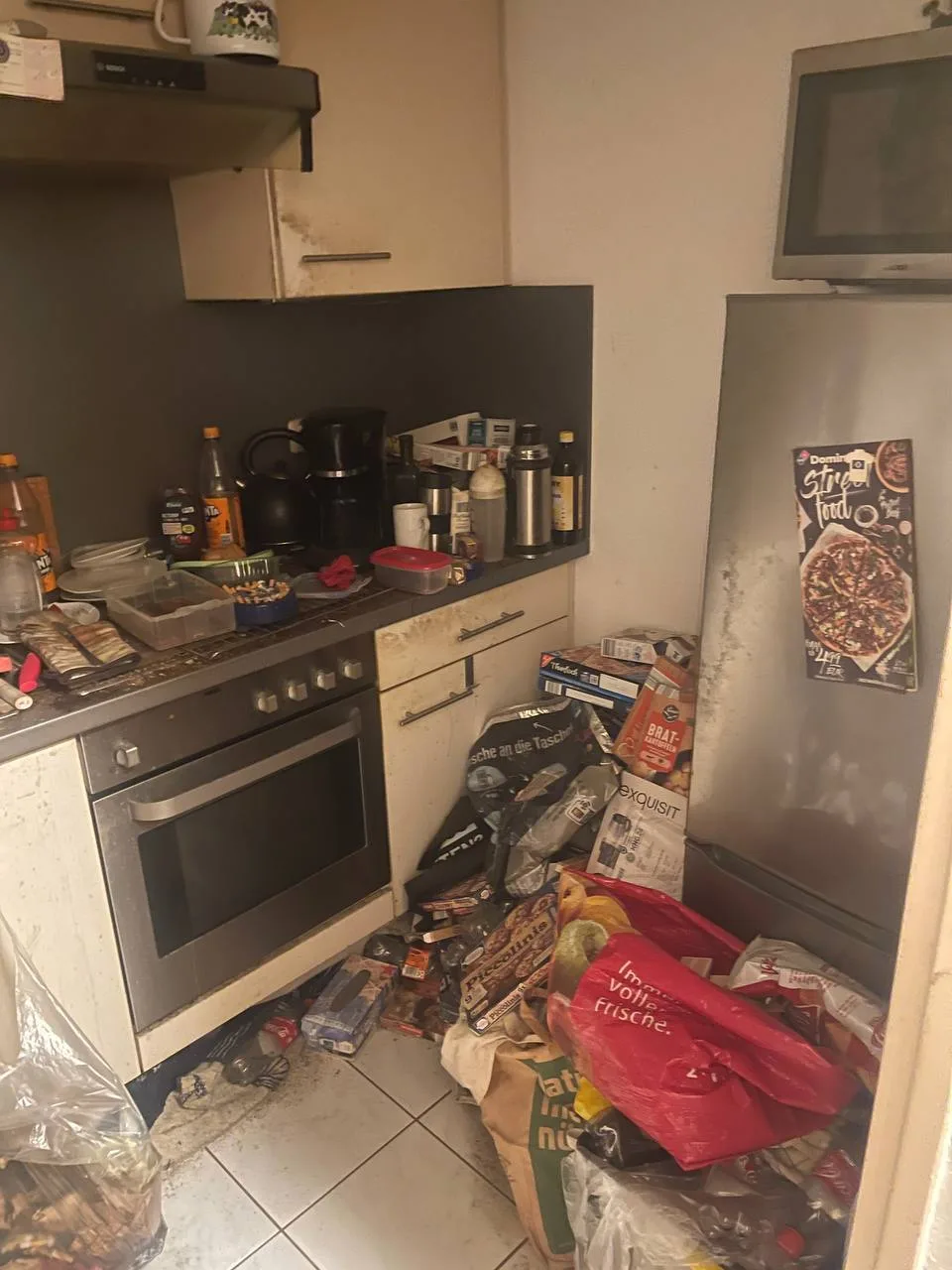 Vermüllte Küche in Hamburg-Wandsbek vor der Entrümpelung, Müllsäcke und Verpackungen auf dem Boden