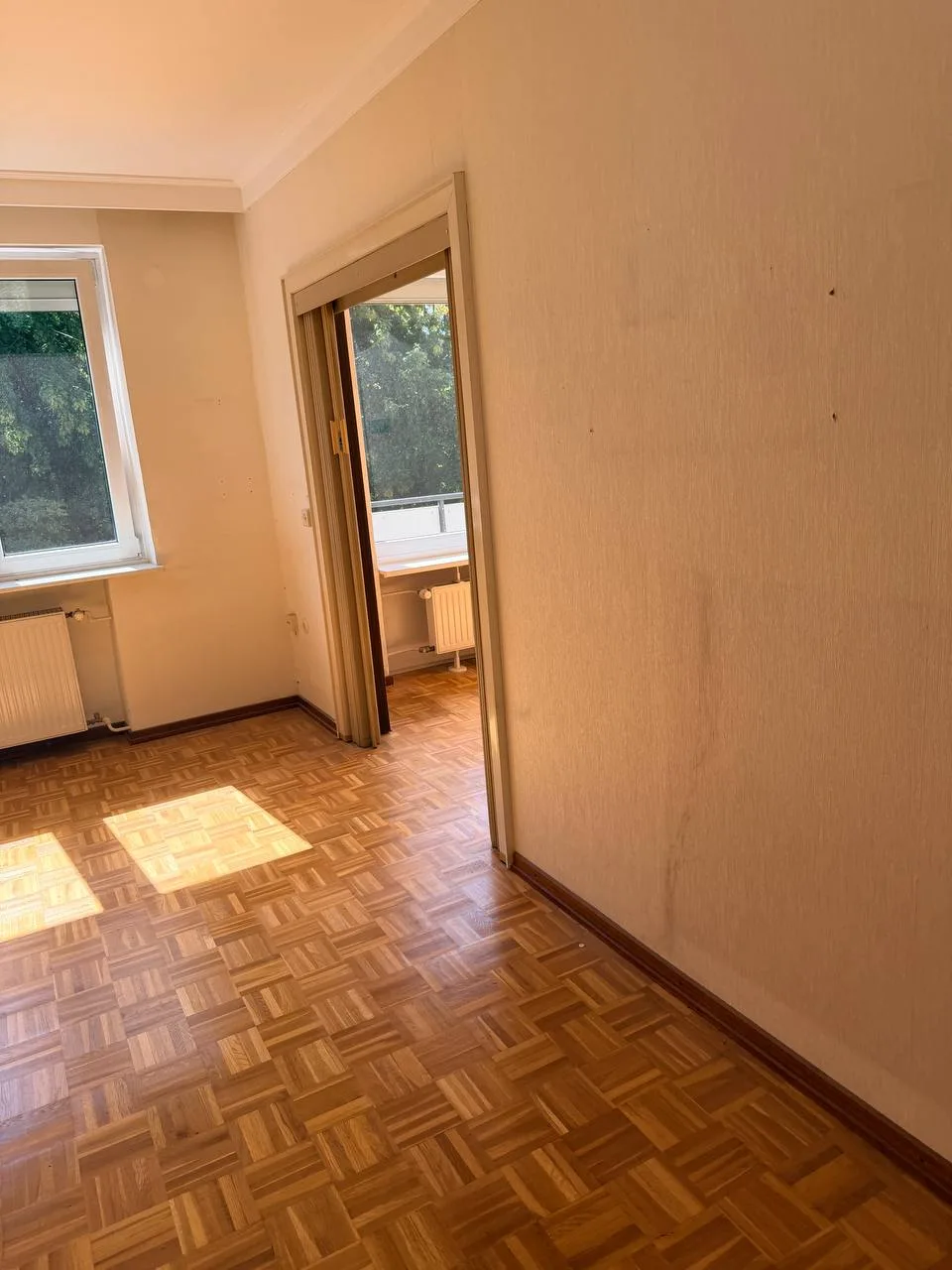 Leeres Zimmer mit Fenster und Durchgang zum Balkon in Hamburg-Wandsbek nach der Räumung
