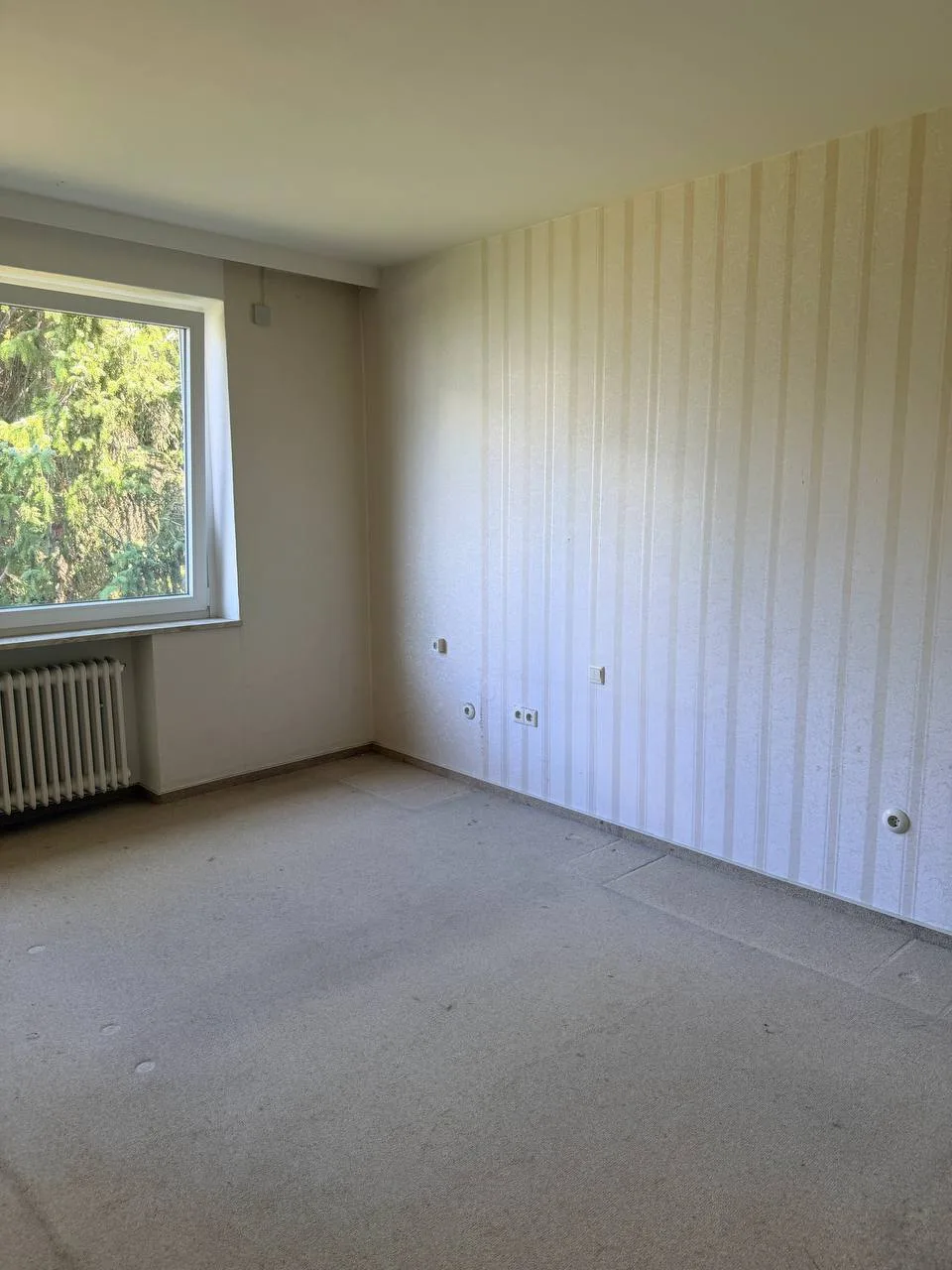 Leeres Schlafzimmer mit Teppichboden und gestreifter Tapete in Hamburg-Wandsbek