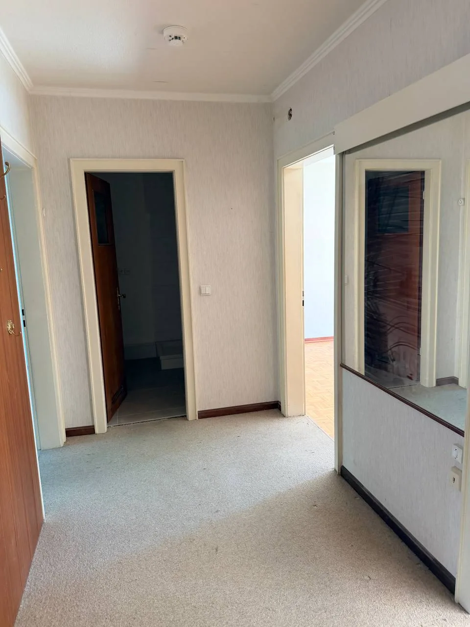 Leere Diele mit Teppichboden und offenen Türen nach der Wohnungsauflösung in Hamburg-Wandsbek